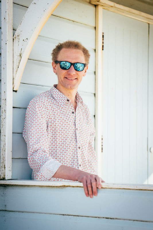 Man smiling while waring a lotus print shirt